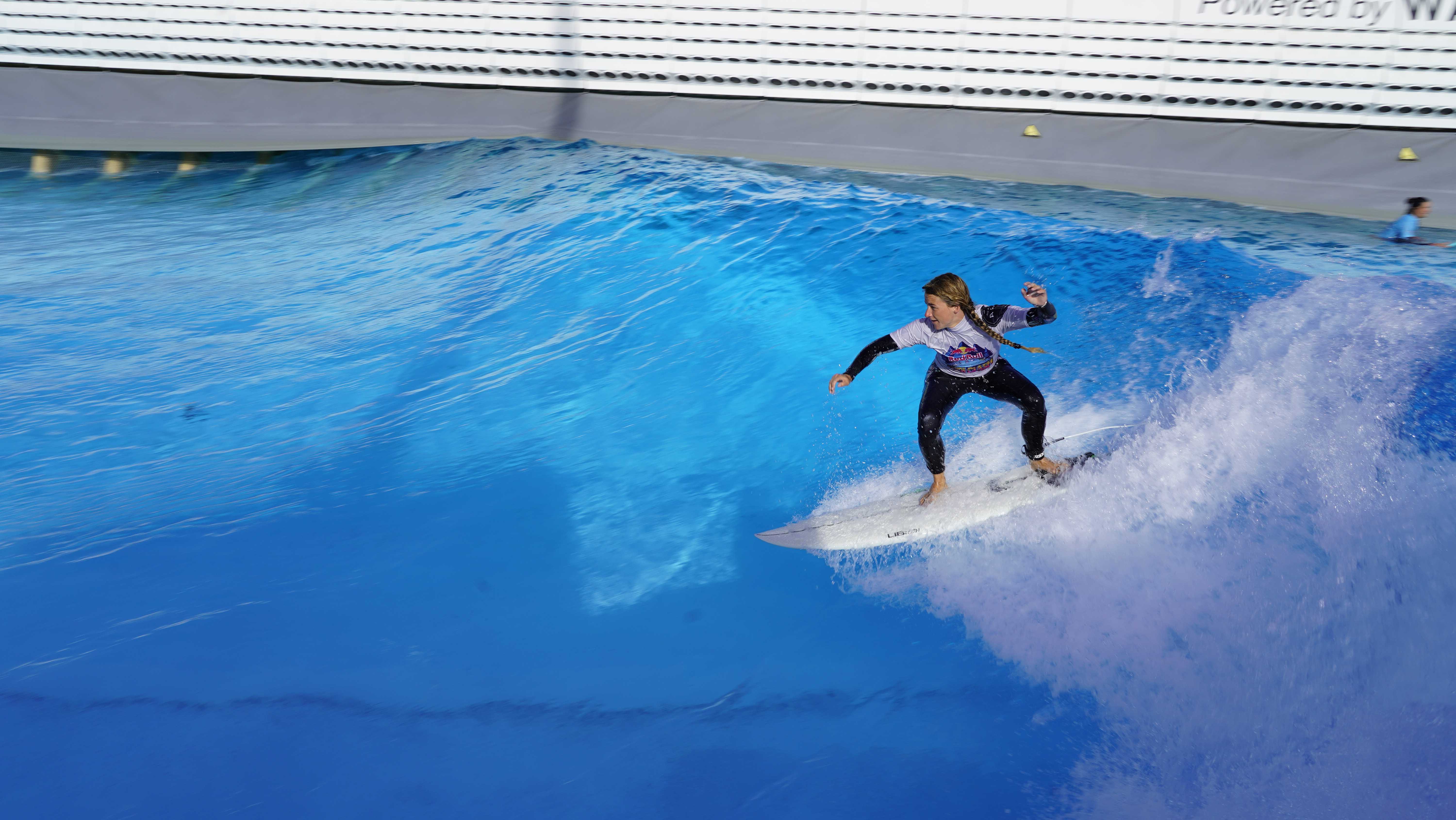 Surfer on a board, riding a wave in a Wavegarden cove