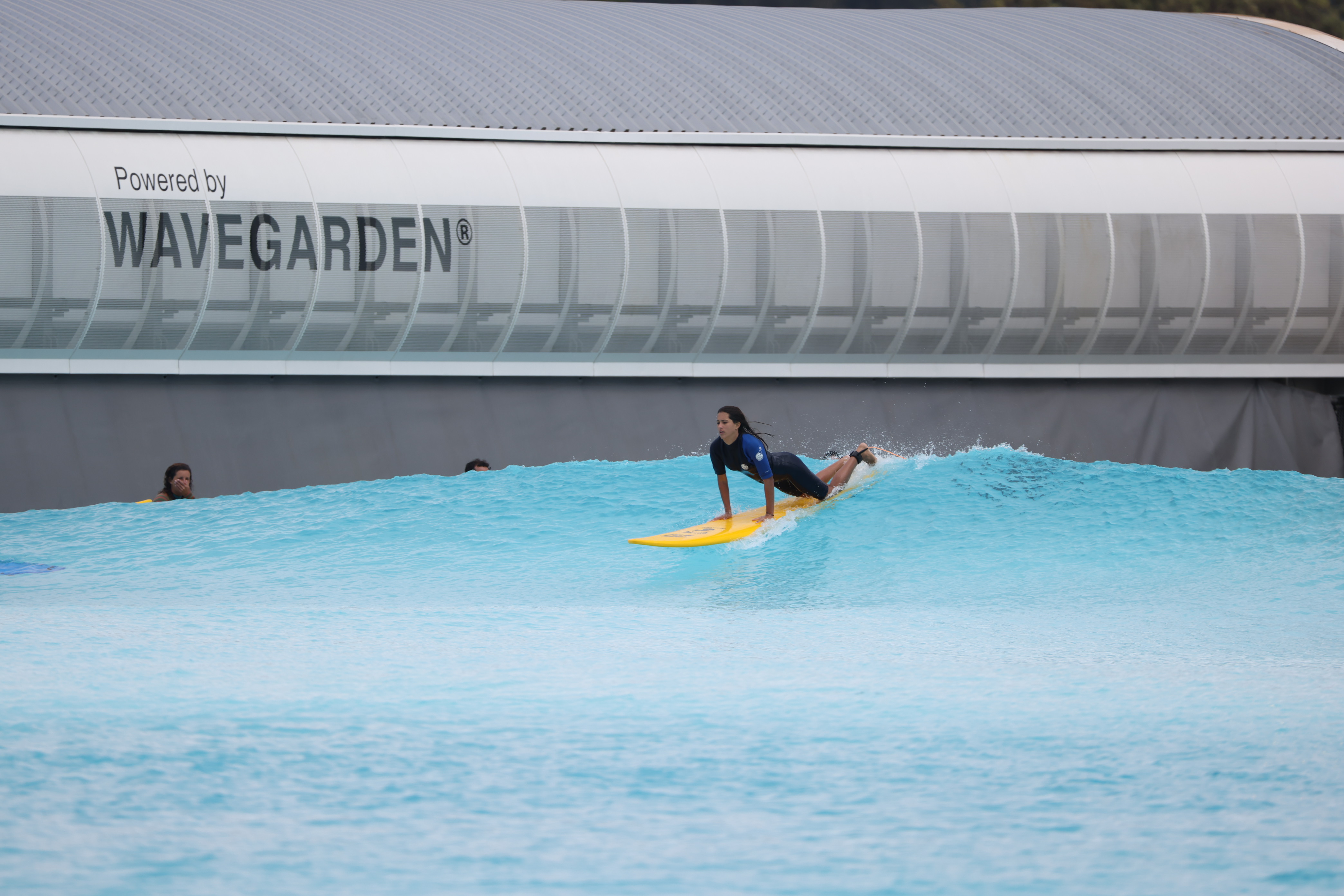 Surfer on a board, riding a wave in a Wavegarden cove