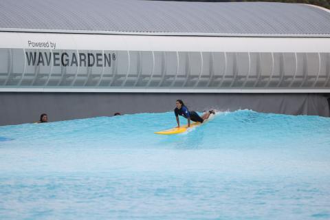 Surfer on a board, riding a wave in a Wavegarden cove